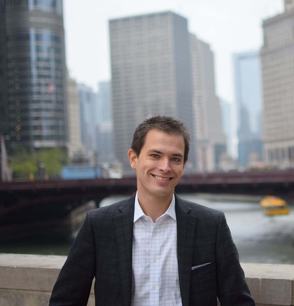 Stephen Petrock wearing a suit with city in the background